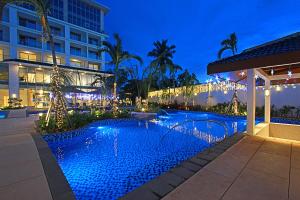 a swimming pool in front of a building at night at Luxu Hotel and Resort in Panglao Island
