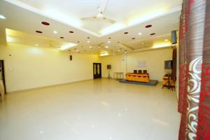 a large room with a ceiling fan and a stage at Hotel Sai Palace Executive Lodging in Bīr +2 photos