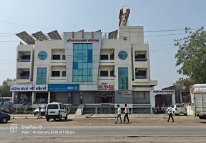 a building with people walking in front of it at Hotel Sai Palace Executive Lodging in Bīr