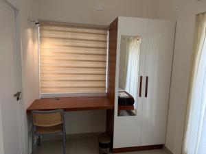 a room with a window with a desk and a chair at Balcony inn in Nedumbassery