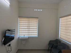 a waiting room with a sink and two windows at Balcony inn in Nedumbassery