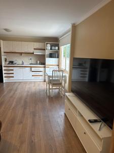 a kitchen with a large flat screen tv and a table at Shaun place in Old Reynella +3 photos