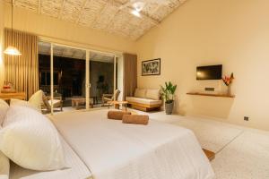 a bedroom with a white bed and a living room at Tropical trails by wija house-unawatuna in Unawatuna