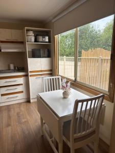 a kitchen with a table and two chairs and a window at Shaun place in Old Reynella