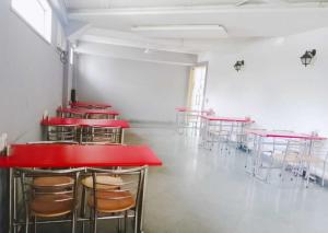 a row of tables and chairs in a room with red tables at Stays - Golf Course Road in Gurgaon
