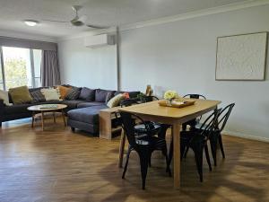 a living room with a table and a couch at Fairways Golf & Beach Retreat Bribie Island in Woorim