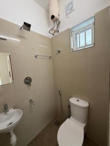 a bathroom with a toilet and a sink at Balcony inn in Nedumbassery