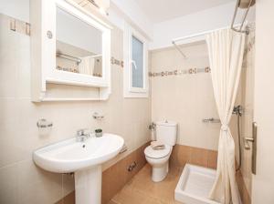a white bathroom with a sink and a toilet at Leonardos Apartments in Naousa +51 photos