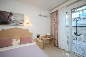 a bedroom with a bed and a balcony at Leonardos Apartments in Naousa