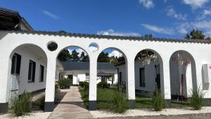 a white building with arches on the side at Pensjonat Eden Apartament 8 in Borne Sulinowo
