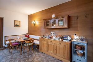 a kitchen with wooden cabinets and a table with chairs at Gästehaus Kopp in Stumm +12 photos