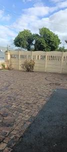 a fence in front of a building with trees in the background at Accomodation in Cape Town in Goodwood