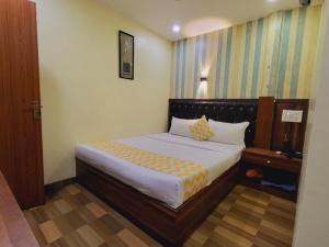 a bedroom with a large bed with yellow and white sheets at Airport Inn Residency Mumbai in Mumbai
