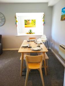a dining room with a wooden table and chairs at Parkside Apartment Normanton in Wakefield +40 photos