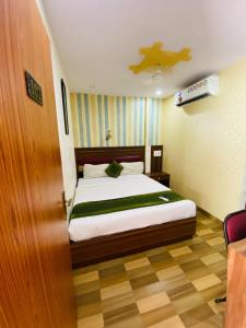 a bedroom with a bed and a ceiling at Airport Inn Residency Mumbai in Mumbai