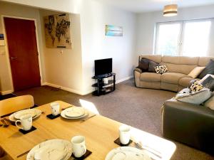 a living room with a table and a couch at Parkside Apartment Normanton in Wakefield