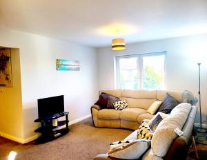a living room with a couch and a television at Parkside Apartment Normanton in Wakefield