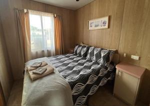a bedroom with a bed with a zebra patterned blanket at KI Caravan Park, Kingscote in Kingscote