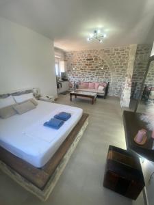 a bedroom with a large bed and a brick wall at Yulie's Orama in Areopoli