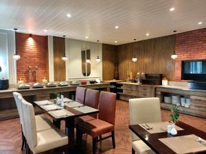 a dining room with a table and chairs and a kitchen at Best Western Dalhousie in Dalhousie