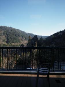 a bench sitting on a balcony with a view of a mountain at 光沙の森 in Hakone
