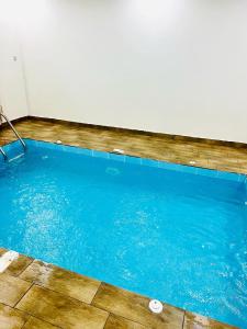 a large swimming pool with blue water in a room at شاليهات زارا in Taif