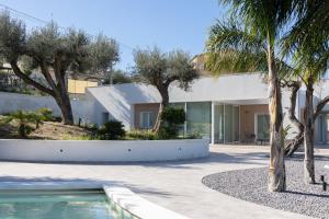 a house with a swimming pool and palm trees at Villa Teresa in Cefalù