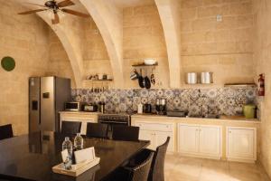 a kitchen with a refrigerator and a table with chairs at Ta' Frenc Farmhouse in Għarb