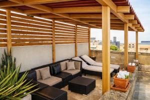 a patio with a couch sitting under a pergola at Ta' Frenc Farmhouse in Għarb