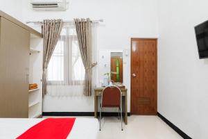 a bedroom with a desk and a bed at RedDoorz at Batutulis Bogor by House of M in Bogor