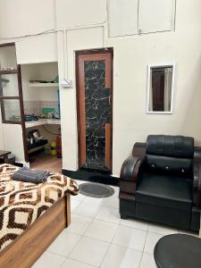 a room with a bed and a couch and a glass door at The Quiet corner 1RK Downtown in Guwahati