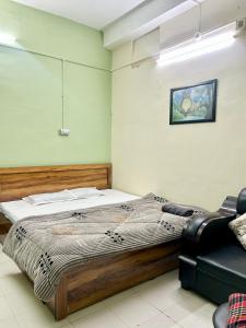 a bedroom with a bed and a chair at The Quiet corner 1RK Downtown in Guwahati