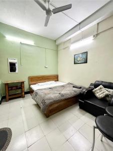 a bedroom with a bed and a couch in it at The Quiet corner 1RK Downtown in Guwahati