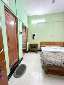 a bedroom with a bed and a wooden door at The Quiet corner 1RK Downtown in Guwahati