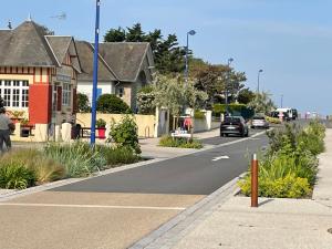 a street with houses and cars on the road at Gite les trois Petiots in Pirou
