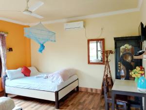 a room with a bed and a table and a mirror at Hotel Rhino Land-Sauraha Family Home in Sauraha +46 photos