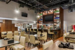 a restaurant with tables and chairs and a bar at Clarion Hotel & Suites in Brandon