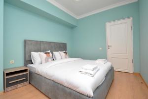 a bedroom with a large bed with blue walls at Domel Yerevan Moskovyan 28 in Yerevan