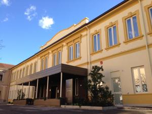 un gran edificio amarillo con ventanas en una calle en Sole Hotel Verona, en Verona