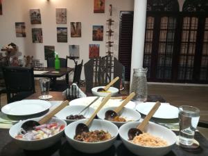 a table with bowls of food and wooden spoons at Mango Oasis - Holiday Bangalow in Habarana +32 photos