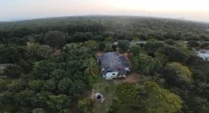 an aerial view of a house in the middle of a forest at Mango Oasis - Holiday Bangalow in Habarana