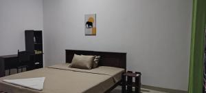 a bedroom with a bed and a picture on the wall at Mango Oasis - Holiday Bangalow in Habarana