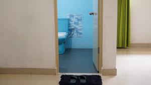 a bathroom with a toilet and a pair of shoes at Mango Oasis - Holiday Bangalow in Habarana