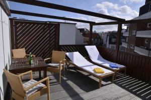 a patio with a table and chairs on a balcony at Hotel Haus Margarete am Meer in Norderney