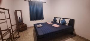 a bedroom with a bed with blue sheets and pillows at Tiny Villa Homestay - ONLY FOR FOREIGN BOOKINGS in Kurunegala +64 photos