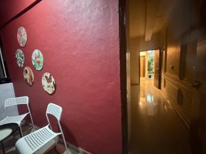 a red wall with chairs and plates on it at The Hampiness in Hospet +16 photos