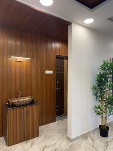 a bathroom with a sink and a wooden wall at The Hampiness in Hospet