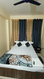 a bedroom with a large bed with black and white sheets at Atithi Stay in Patna
