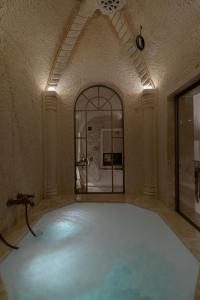 a room with a pool of blue water at Via Regia Cappadocia Hotel in Uçhisar