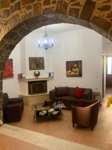 a living room with a couch and a fireplace at Creta guesthouse ARXONTIKO! in Smárion